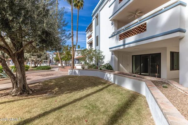 a view of a house with cars park side of a road