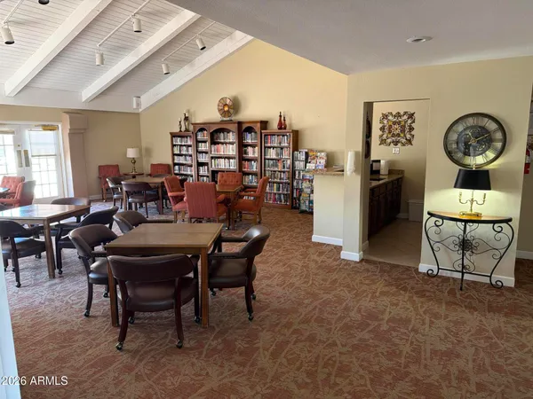 a room with pool table and two windows