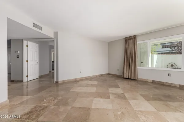 an empty room with windows and mirror