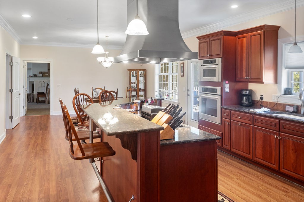 758 Holt Road Lebanon, TN 37087 - Photo 12 of 55 a kitchen with stainless steel appliances kitchen island granite countertop a table chairs in it and wooden floors
