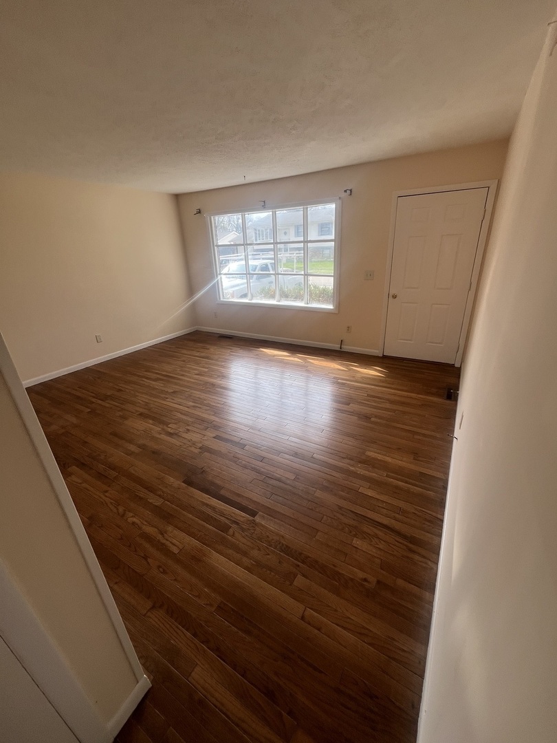 1720 Jacobssen Drive Normal, IL 61761 - Photo 3 of 13 an empty room with wooden floor and windows
