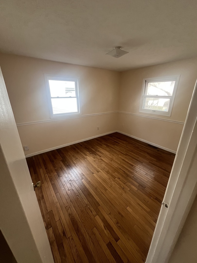 1720 Jacobssen Drive Normal, IL 61761 - Photo 7 of 13 a view of an empty room with wooden floor and a window