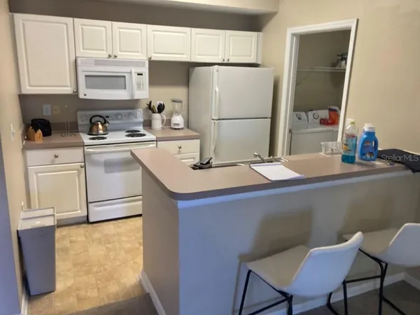 a kitchen with a sink a refrigerator and cabinets