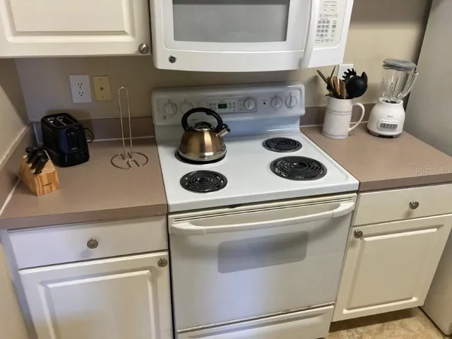 a close view of stove and white cabinets