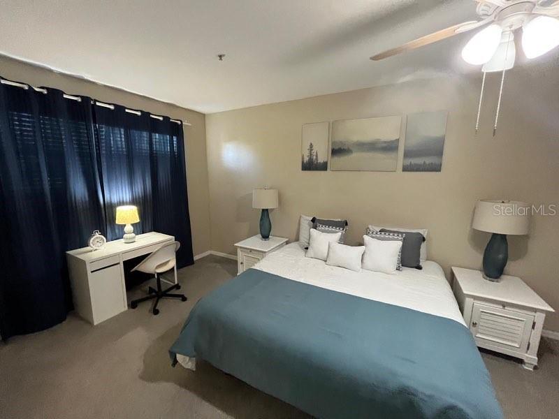 5512 Metrowest Boulevard, Unit 304 Orlando, FL 32811 - Photo 8 of 12 a bed room with a bed and a lamp