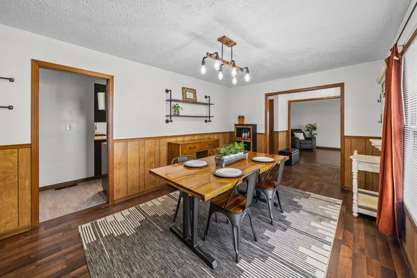 a dining room with wooden floor and large windows