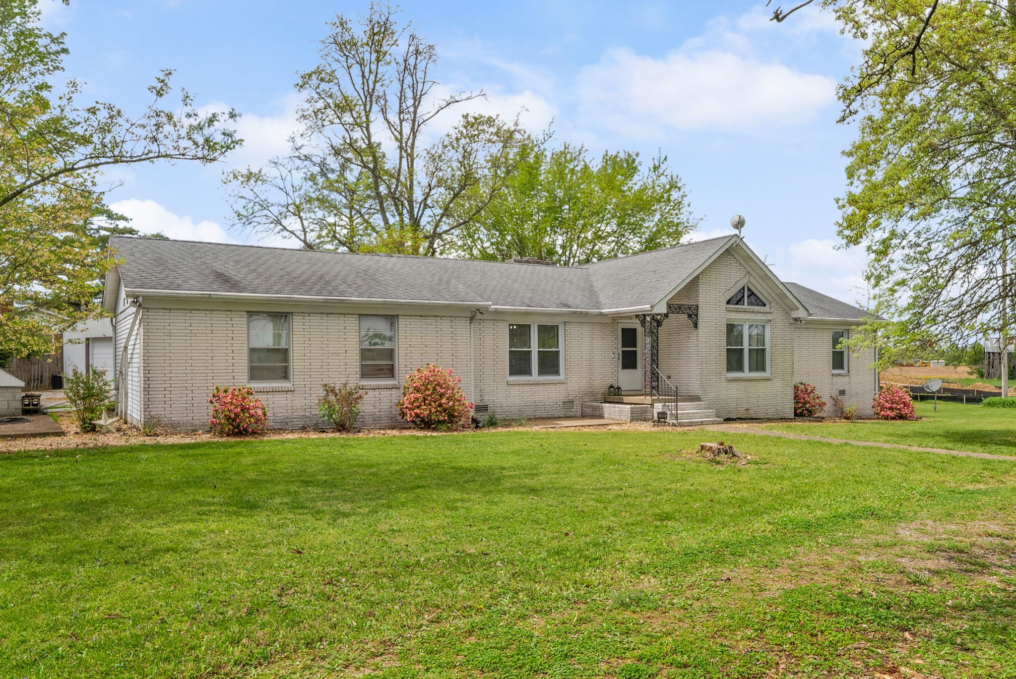 3801 Allegre Road Elkton, KY 42220 - Photo 23 of 36 a front view of a house with a garden and trees