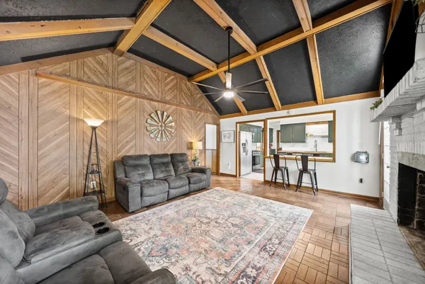 a living room with a fireplace a flat screen tv and a window