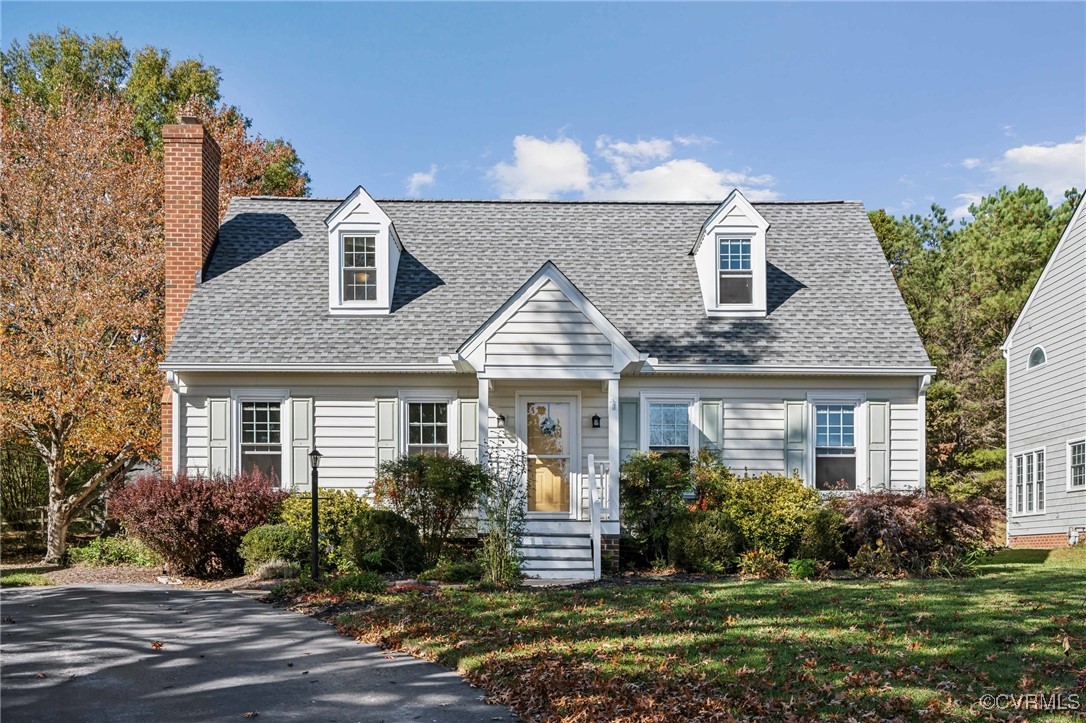 New england style home featuring a front yard