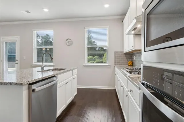 a kitchen with granite countertop a stove and a sink