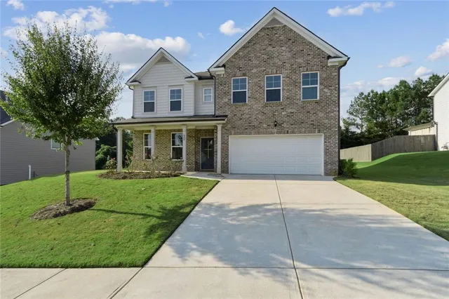 a front view of a house with a garden and yard
