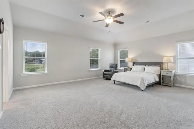 a spacious bedroom with a bed and a chandelier