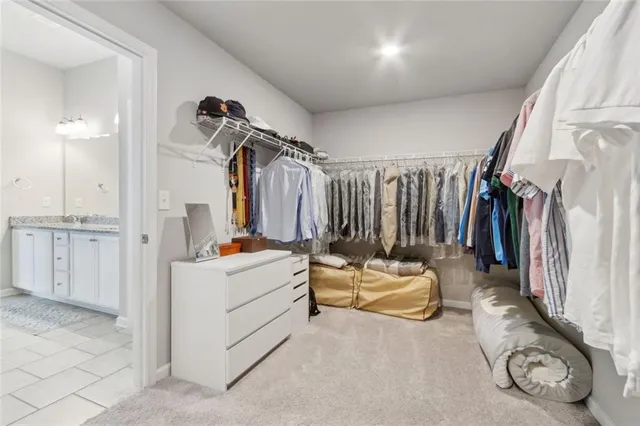 a view of walk in closet with clothes and shoes