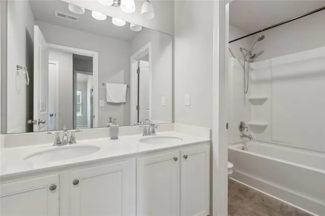 a bathroom with a double vanity sink mirror double and bathtub
