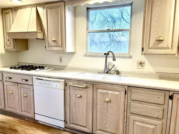a kitchen with white cabinets and a window