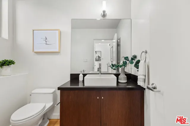 a bathroom with a granite countertop sink and a toilet