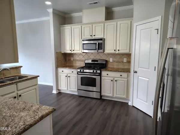a kitchen with stainless steel appliances granite countertop a stove a sink and a refrigerator