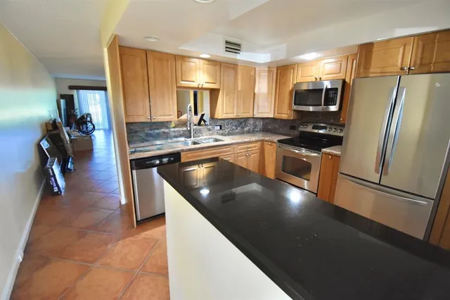 a kitchen with stainless steel appliances granite countertop a sink stove and refrigerator