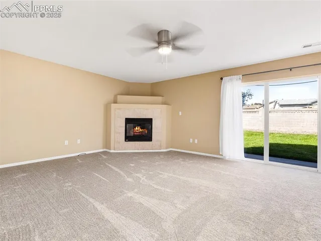 a view of an empty room with a fireplace and a window