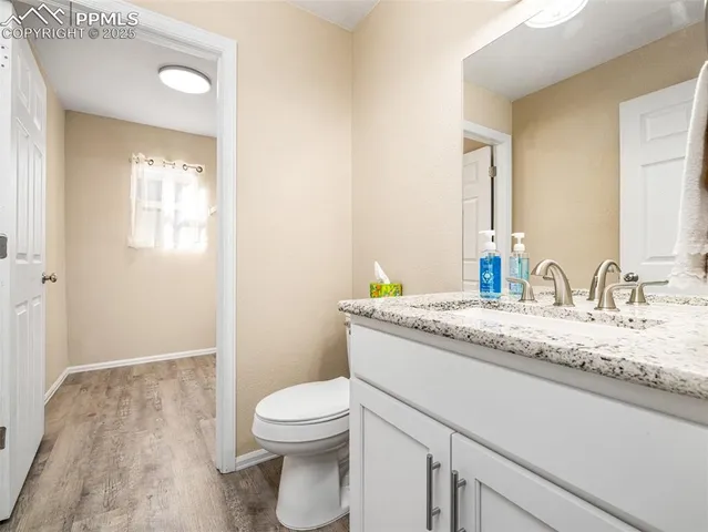 a bathroom with a granite countertop sink a toilet and a mirror