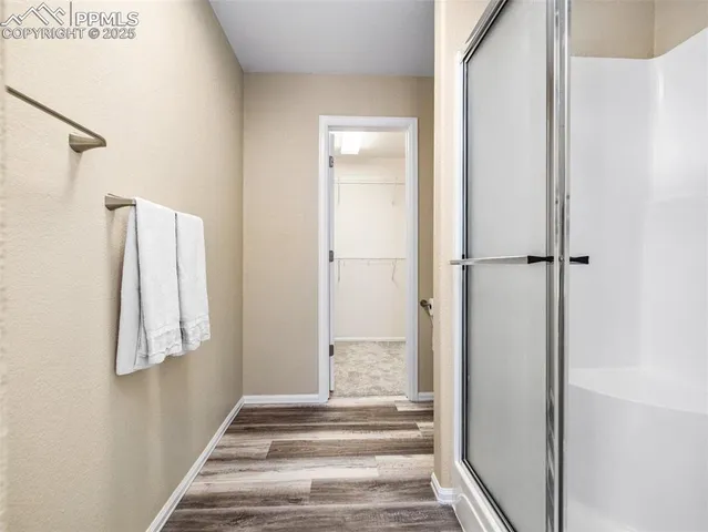 a view of a hallway with wooden floor and entryway