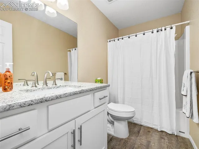 a bathroom with a granite countertop sink toilet and a mirror