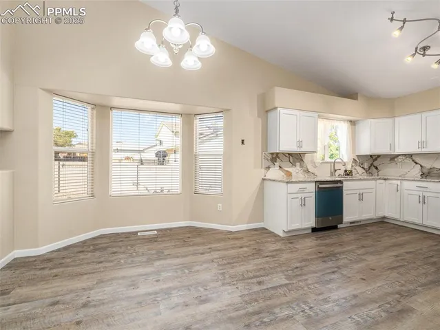 a kitchen with a stove a sink cabinets and a window