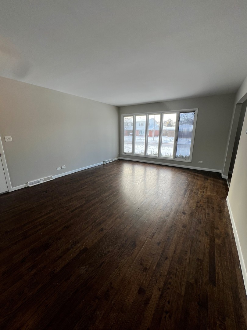 1171 South Ridge Avenue Arlington Heights, IL 60005 - Photo 2 of 12 an empty room with wooden floor and windows