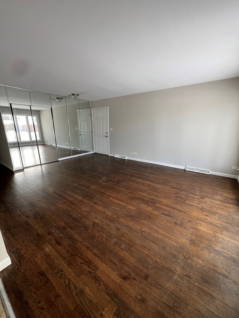 1171 South Ridge Avenue Arlington Heights, IL 60005 - Photo 5 of 12 an empty room with wooden floor and windows