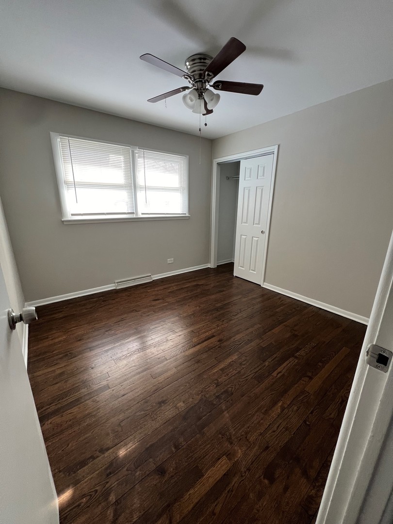 1171 South Ridge Avenue Arlington Heights, IL 60005 - Photo 8 of 12 an empty room with wooden floor fan and windows