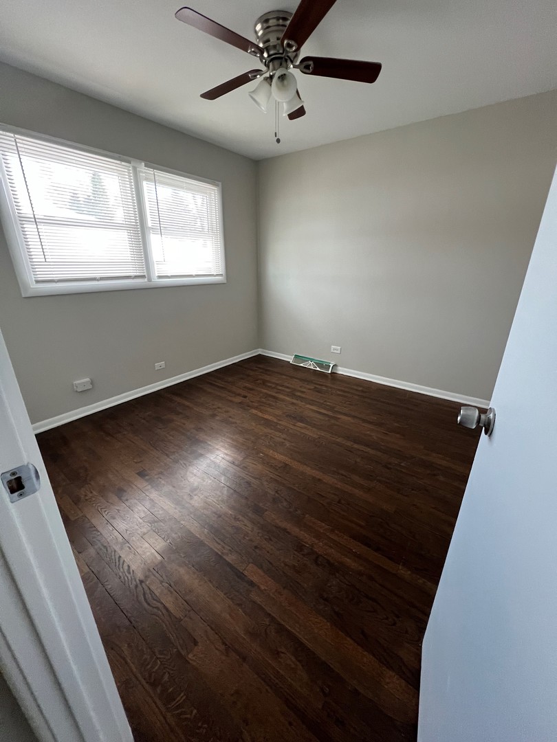 1171 South Ridge Avenue Arlington Heights, IL 60005 - Photo 9 of 12 an empty room with wooden floor fan and windows