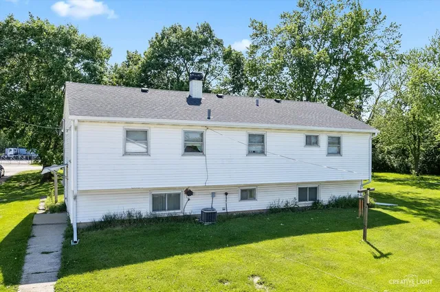 a aerial view of a house next to a big yard and large trees