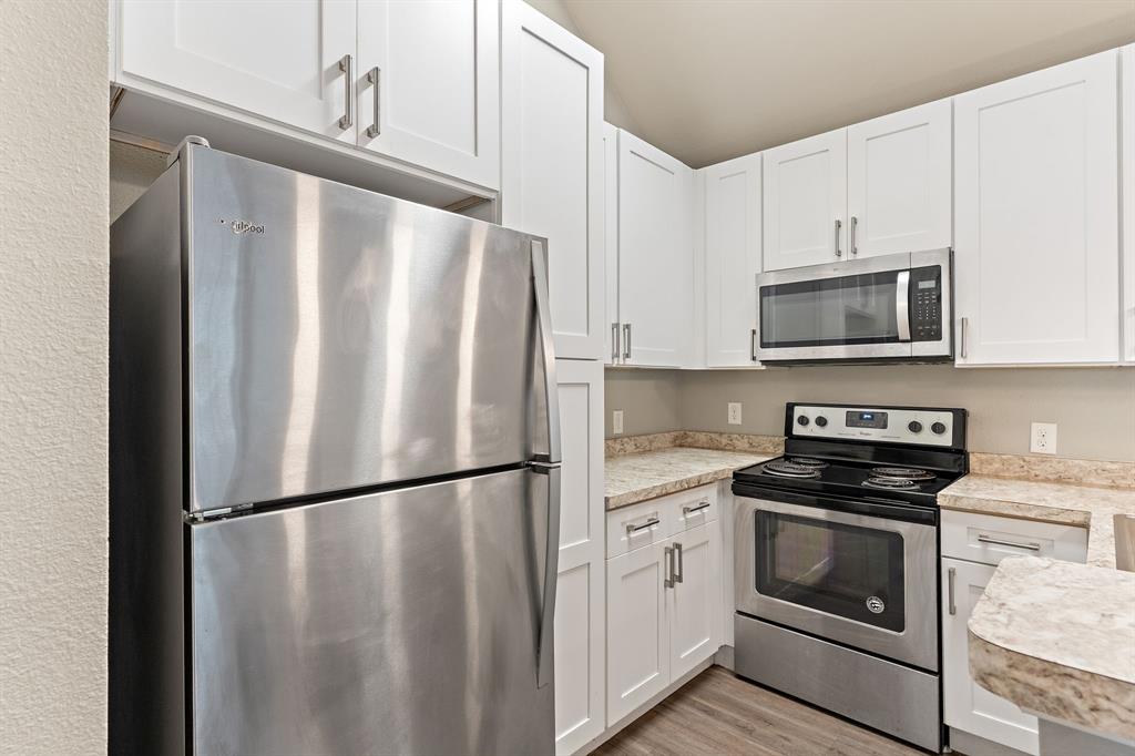 6108 Abrams Road, Unit 521 Dallas, TX 75231 - Photo 7 of 31 a kitchen with a refrigerator stove and microwave