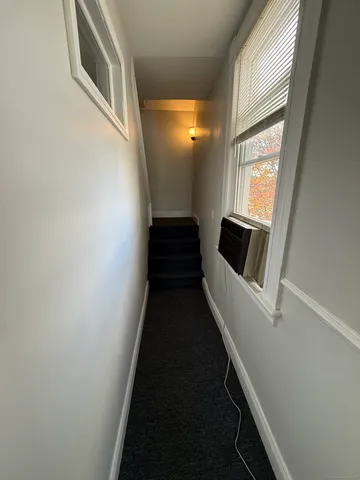 a bathroom with a sink a toilet a shower and a window