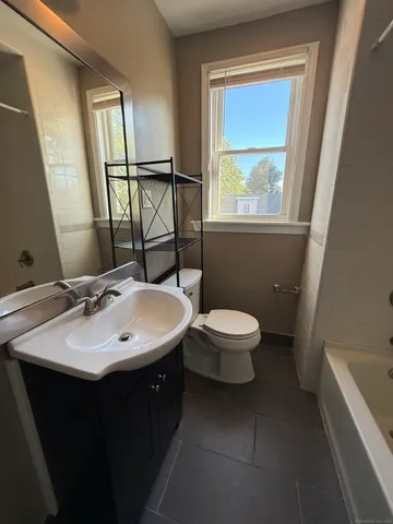 a bathroom with a toilet sink and mirror