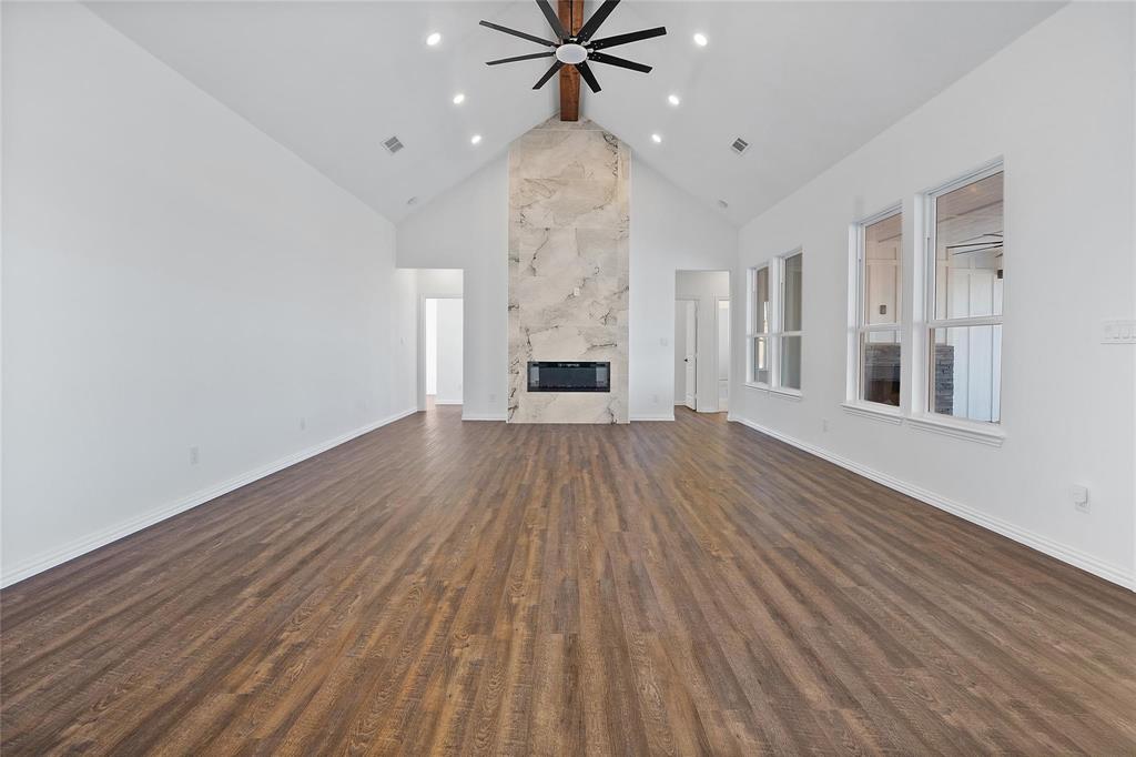 3093 Willow Road Celeste, TX 75423 - Photo 11 of 40 a view of a livingroom with wooden floor a ceiling fan and kitchen space