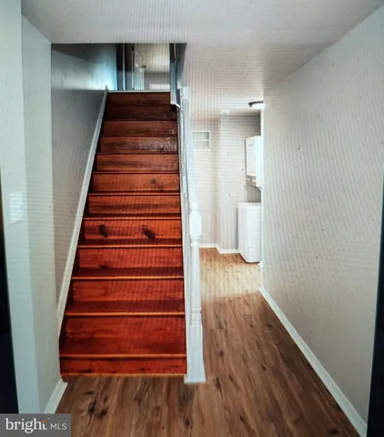 a view of a hallway with wooden floor and stairs