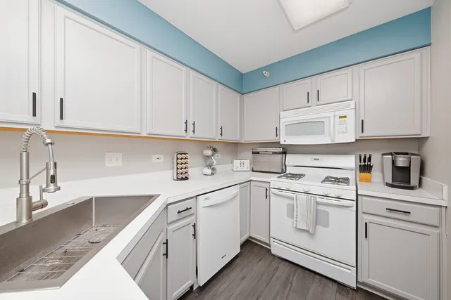 a kitchen with white cabinets and white appliances