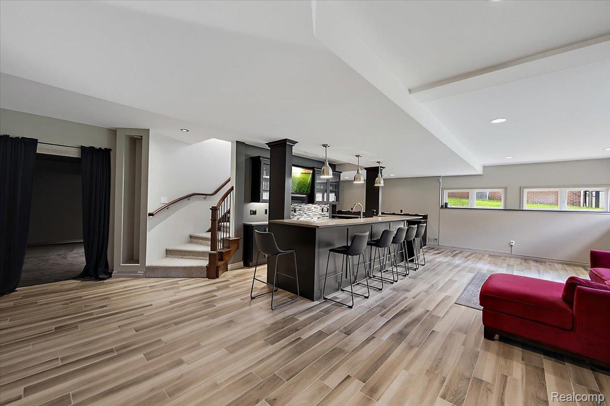 1422 Galena Rochester, MI 48306 - Photo 49 of 73 Finished lower level featuring wood-finish flooring, a full-service bar with pendant lighting, recessed lighting, and a carpeted staircase with a wood handrail