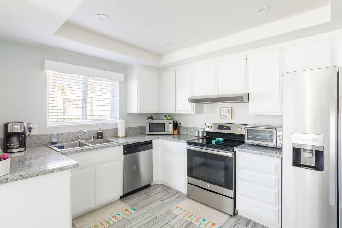 82191 Waring Way Indio, CA 92201 - Photo 11 of 42 a kitchen with white cabinets and white appliances