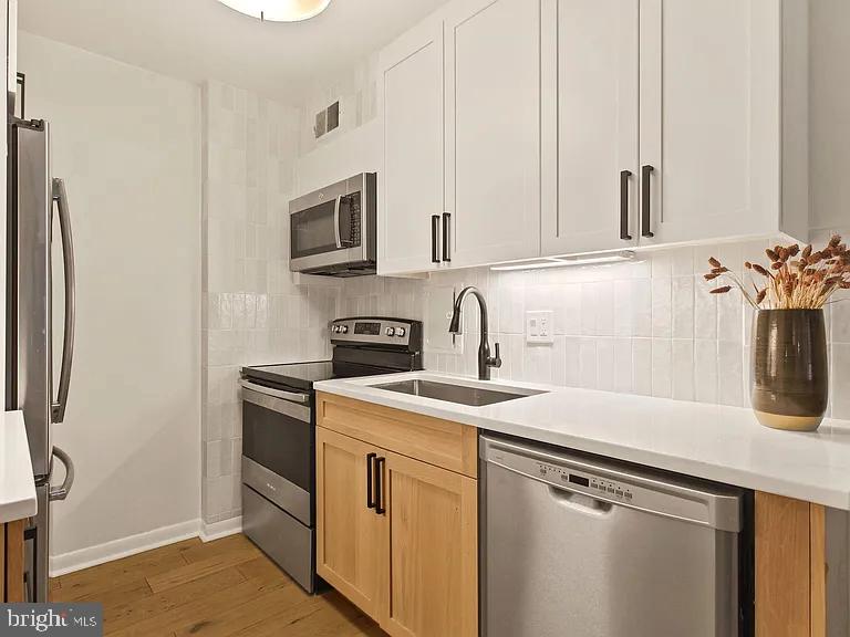 1718 P Street Northwest, Unit T3 Washington, DC 20036 - Photo 4 of 14 a kitchen with stainless steel appliances granite countertop a sink stove and refrigerator