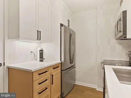 a kitchen with stainless steel appliances granite countertop a refrigerator and a sink