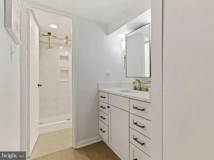 a bathroom with a granite countertop sink a mirror and a bathtub