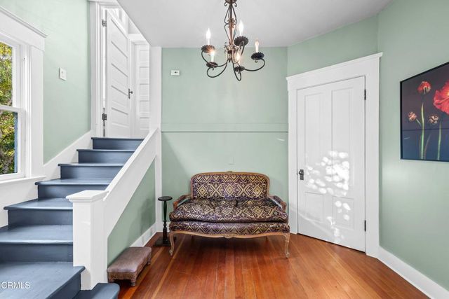 a living room with wooden floor and stairs