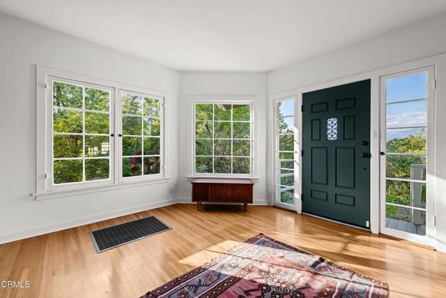 a view of a bedroom with wooden floor and windows