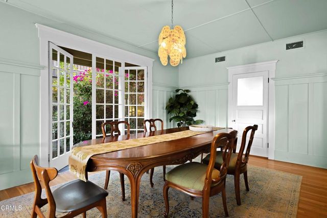 a dining room with furniture a potted plant and a chandelier