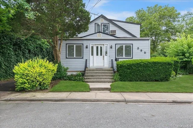 a front view of a house with a garden and plants