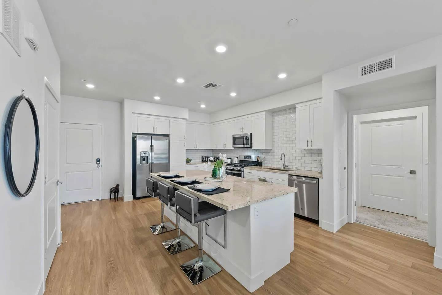 5925 Charlotte Drive, Unit 414 San Jose, CA 95123 - Photo 2 of 18 a open kitchen with stainless steel appliances granite countertop a stove oven a refrigerator a sink and white cabinets with wooden floor