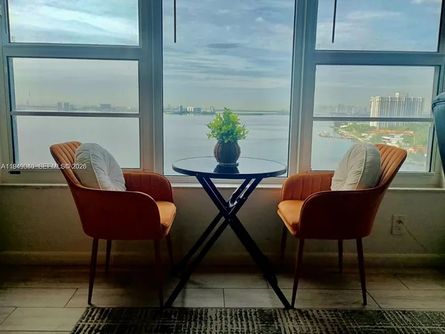 a view of a chairs and table in the balcony