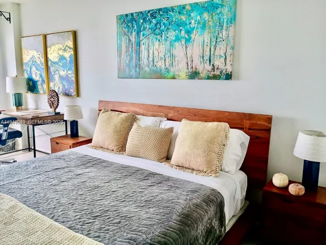 a bed sitting in a bedroom next to a window